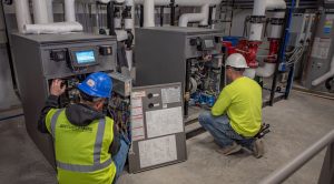 Two men working on a machine in a factory.